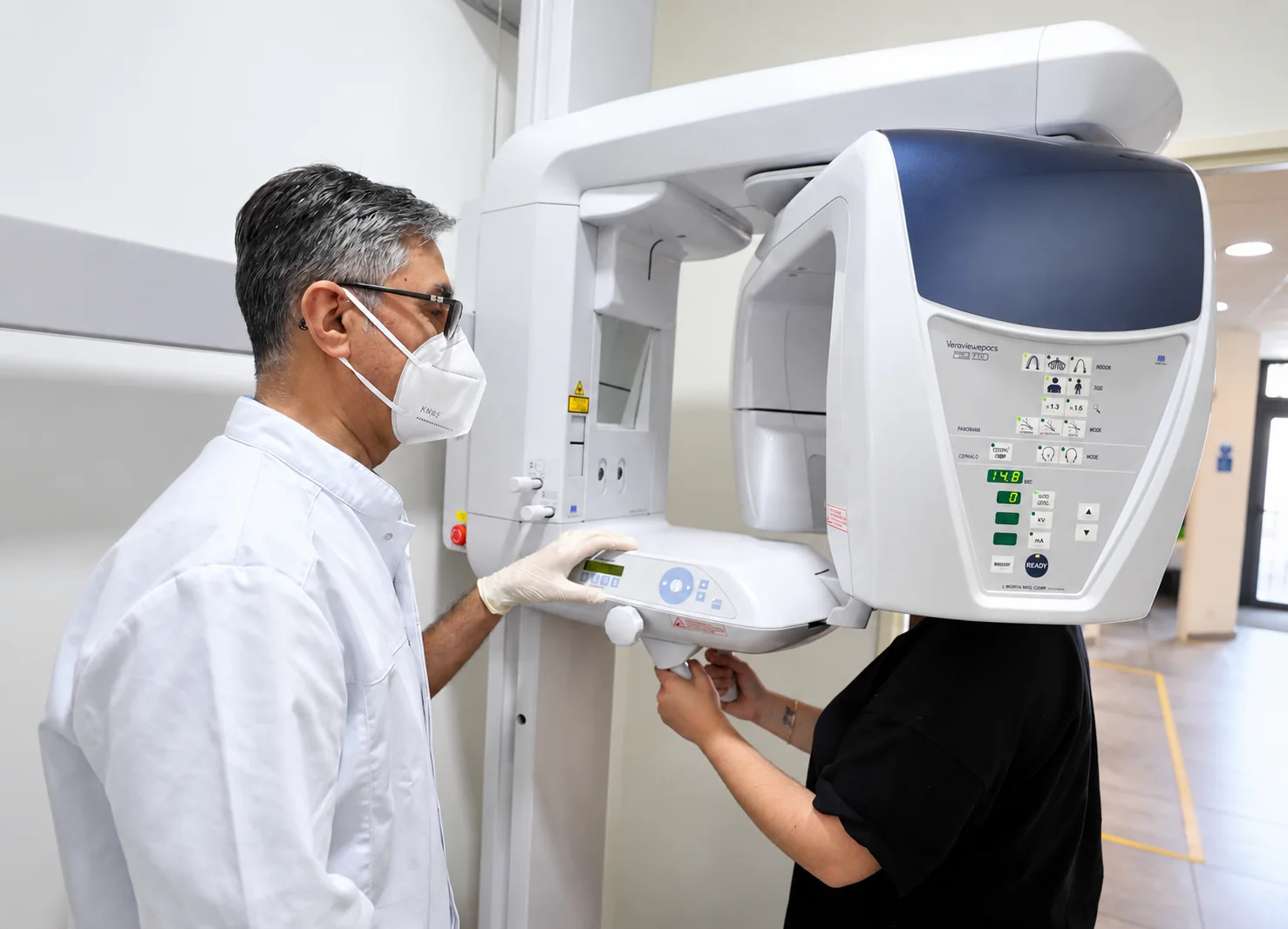 Le Dr Soheili installe un patient pour une radiographie panoramique au cabinet de Nanterre