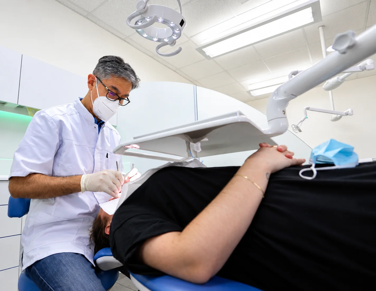 Contention orthodontique à Nanterre : le Dr Soheili en soin auprès d'un patient installé au fauteuil du cabinet