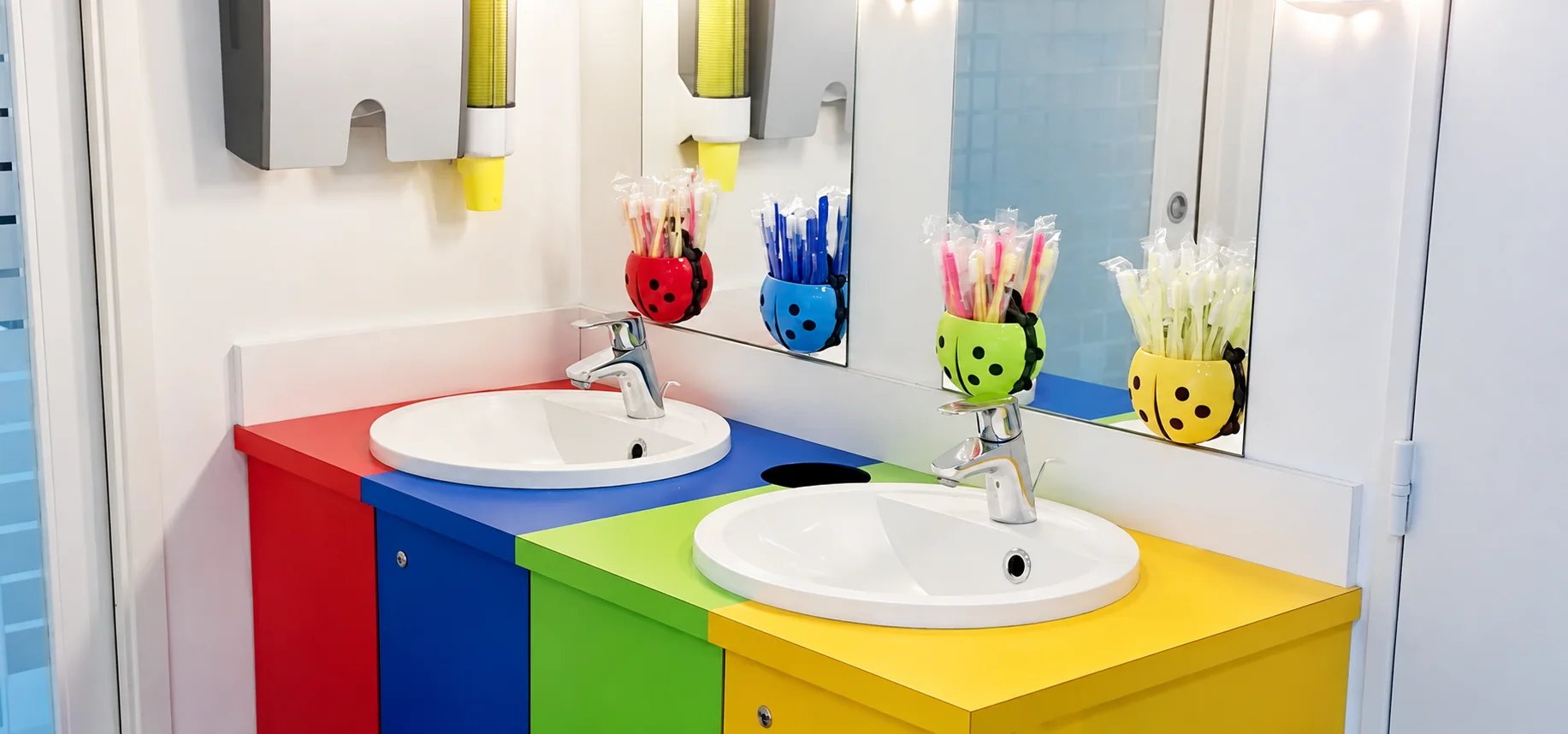 Espace de brossage du cabinet d'orthodontie de Nanterre, avec ses lavabos colorés